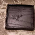 Black rectangular tray with engraved design on a marble surface
